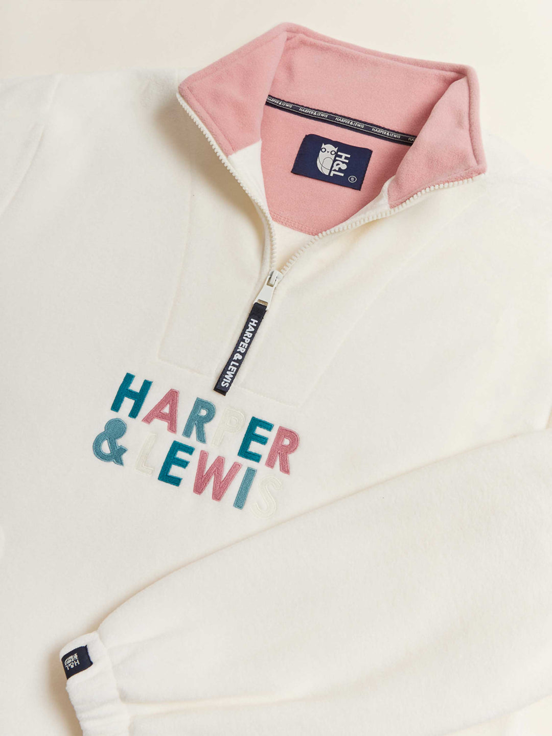 Comfort-fit Harper & Lewis Polar Fleece, with a relaxed silhouette, 1/4 zip collar, and soft fleece texture. Embroidered chest logo adds a refined touch.