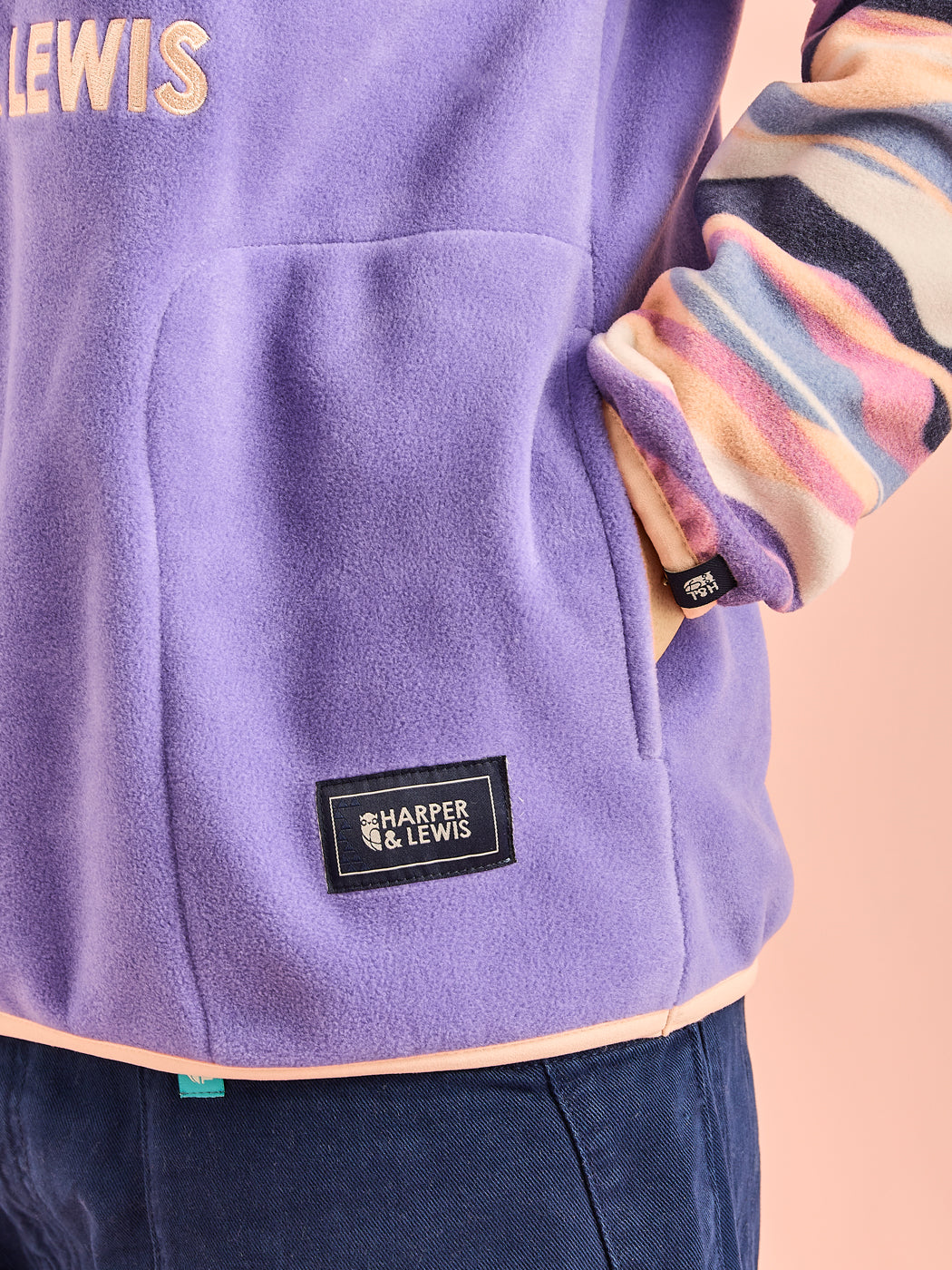 detailed shot of the navy badges on the pocket and the cuff, this also shows the Light Peach binding at Cuff & Hem.
