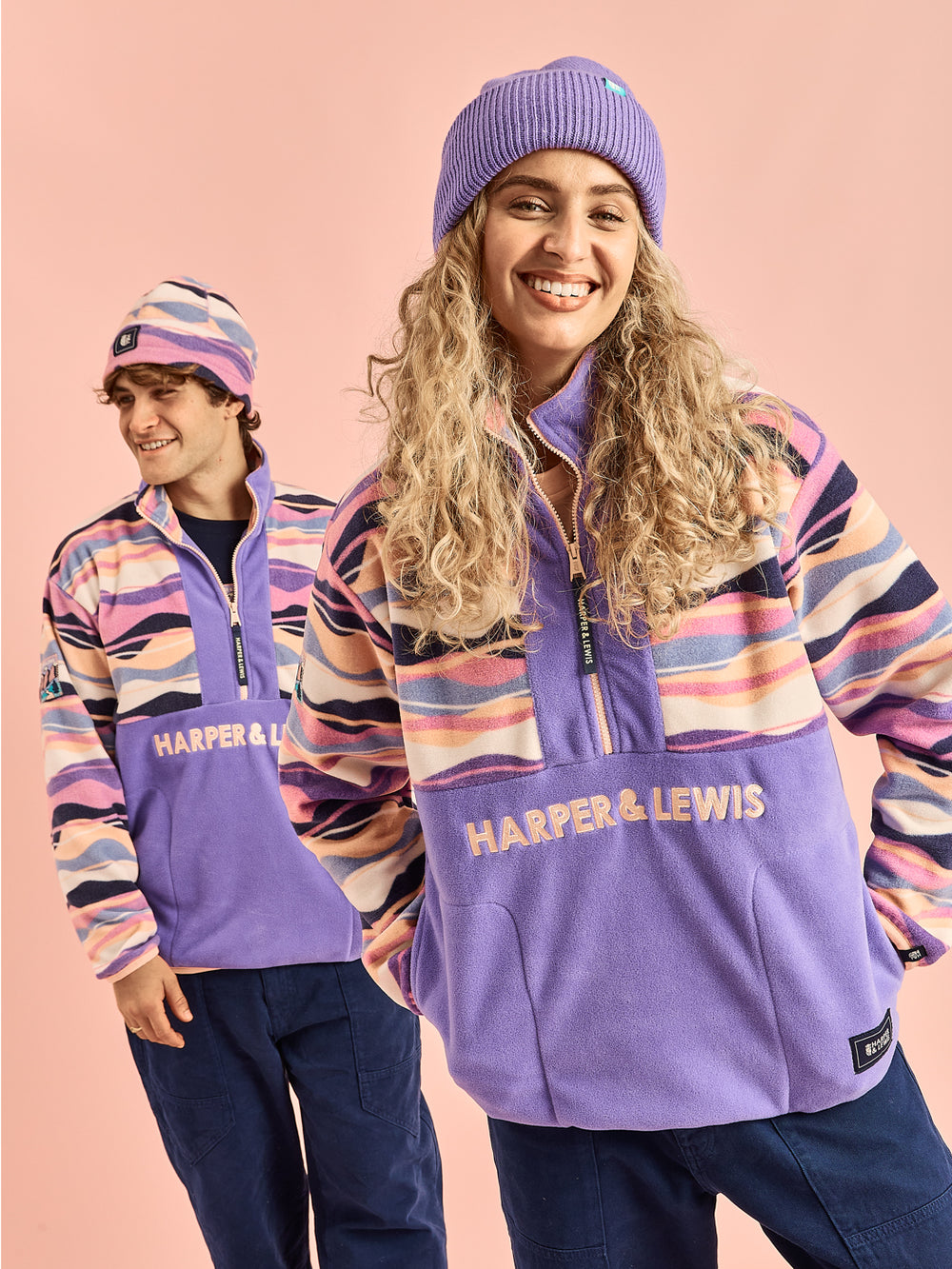 Two Models wearing the new updated unisex fleece in the Mountain Wave pattern and Deep Lavender.