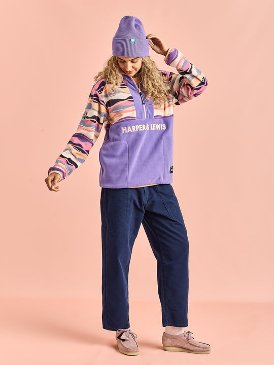 Female model wearing the female fleece, the pattern consists of Light Peach, Pale Airforce, Deep Lavender, Lavender Mist, Navy & Cream.