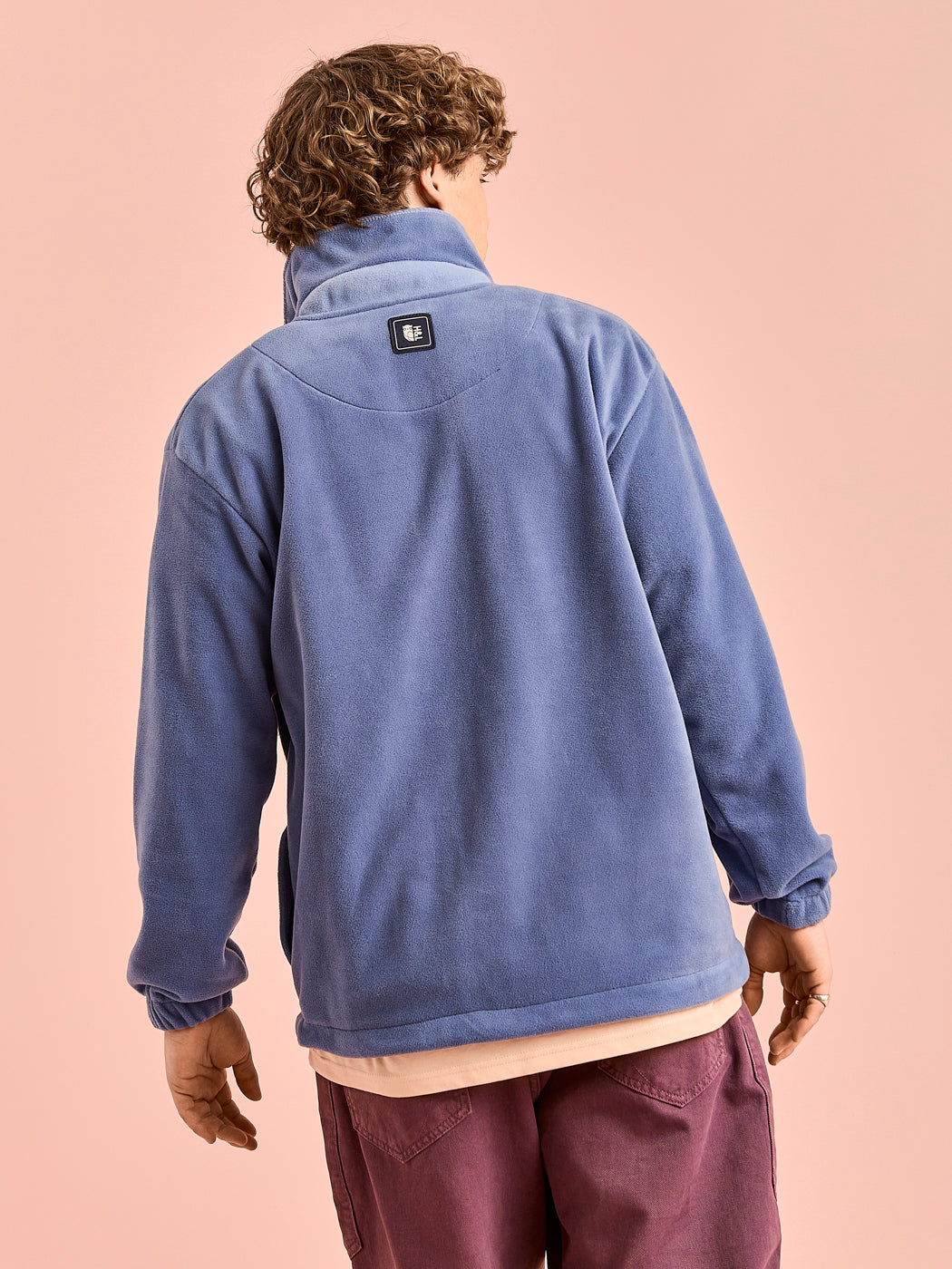 Back shot of the Airforce blue fleece jacket with the navy branded badge on the back neck.