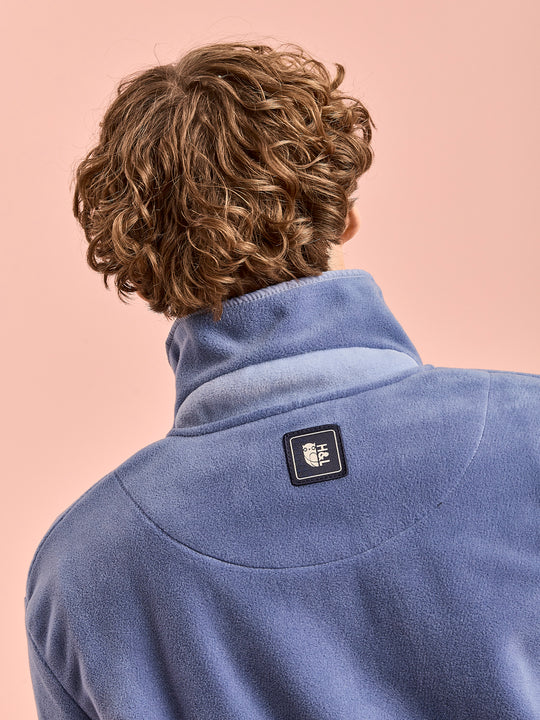 Detail shot of the male model wearing the Airforce fleece with the branded badge on the back yoke.
