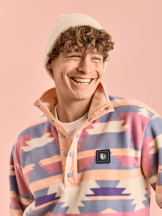 Detail shot of the male model wearing the printed fleece with a woven branded badge 