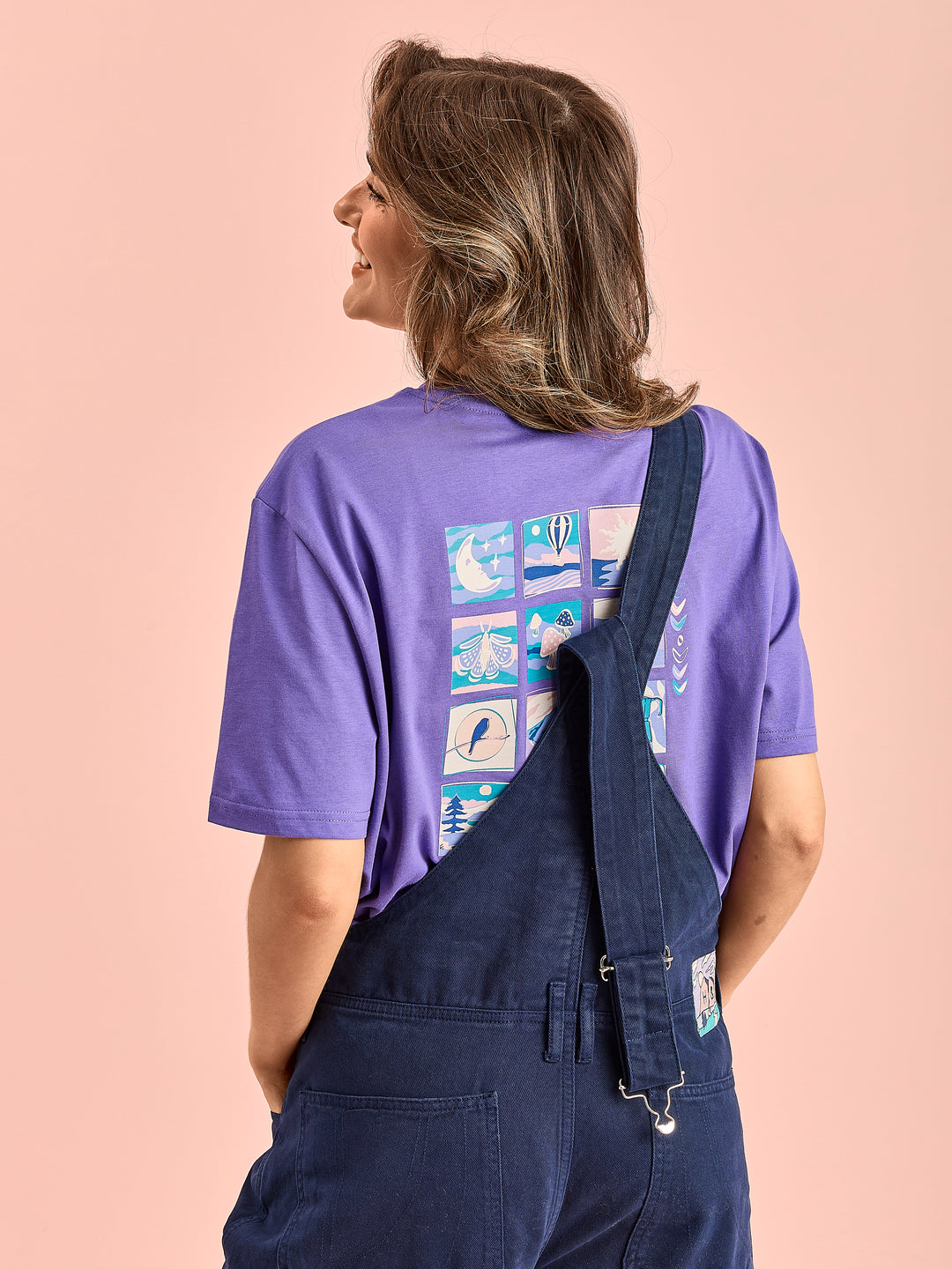 Detail shot of the female model wearing the unisex dungarees, this is showing the one strap