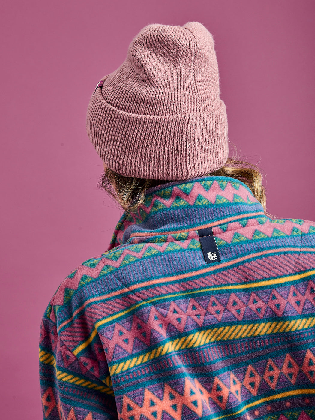 Back shot of the unisex fleece, which shows the branded ack neck tab which can be used a hanging loop