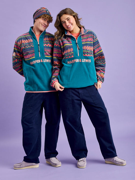 Two Models wearing Aztec Fleeces showing colours of Teal, Dark Rose, Deep Mulberry, Orchid, Deep Peach & Mustard.